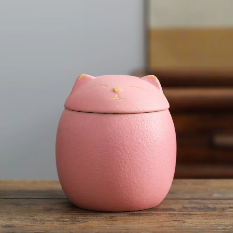 Pink cat-shaped container on a wooden surface with a blurred background
